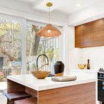 Scalloped Serenity Rattan Pendant hanging above kitchen island with natural light from large window