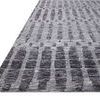 Angled view showing thin profile and corner of Yeshaia Grey / Charcoal Rug on white background