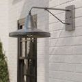 Mariner sconce side view mounted on white brick wall next to black framed windows