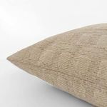 Close-up side view of creamy pillow showing fabric texture and subtle raised checkered knit pattern