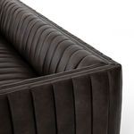 Close cropping focused on soft vertical leather channels of the sofa cushions