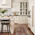 Runner style Jules Merlot / Multi Rug in white kitchen with black stool and wooden floors