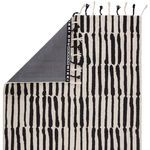Rug flipped to show branded black backing with Nikki Chu logo and fringe details