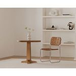 Charles Cafe Table styled in a light minimal room beside a woven leather chair and white vase on table