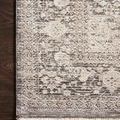 Close-up of Homage Ivory Grey Rug corner showing textured high-low woven pattern and fringed edge on dark wood floor