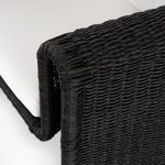 Close-up showing curved wicker armrest wrapping around white seat cushion corner