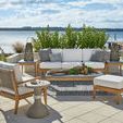 Outdoor patio setting with Chesapeake Lounge Chair among a seating group overlooking water