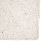Close-up detail of ivory jute rug emphasizing textured diagonal handwoven pattern and natural fiber specks