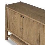 Close-up angled view of sideboard corner showing black knob handles and top surface grain