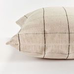 Detail of side zipper closure with matching beige fabric blending in with grid pattern