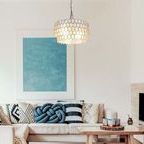 Celeste Capiz Chandelier hanging above living room sofa against minimalist wall art