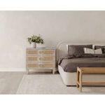 Colin bed positioned next to a light wood chest of drawers with decor in bedroom setting