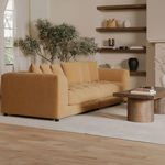 Camel sofa angled view captures plush cushions and soft velvety upholstery with room décor detail.