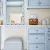 Mirror displayed in built-in closet area with striped blue ottoman and wicker basket nearby