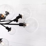 Side close-up focusing on arrangement of glass bulbs and intersecting black iron arms