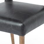 Close-up side angle emphasizing leather-covered backrest curve and posterior cutout