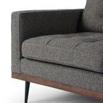 Close-up of left front armrest and seat cushion showing stitch details and fabric texture