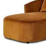 Close-up on front rounded seat edge and velvet fabric texture with small black legs visible