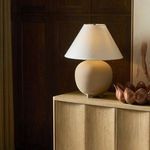Saima Table Lamp on wooden cabinet with dark wood panel wall and copper decor accents