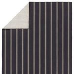 Backside corner of rug folded over, revealing the reverse side with a lighter solid color