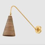 Close-up angle of aged brass arm and detailed weave texture of rattan shade against light background