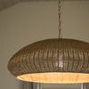 Lit pendant hanging in neutral room casting warm light onto ceiling and curtains