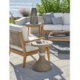Boden Accent Table styled outdoors next to a wooden and fabric armchair on a tiled patio with green plants and water in th...