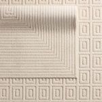 Reverse side of rug folded over with contrasting geometric square pattern in cream tones
