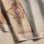 Folded rugs showing overlapping pastel floral rug and a brown rug with geometric patterns