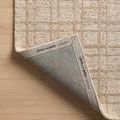 Rug corner slightly lifted showing branded backing with Chris Loves Julia x Loloi logo on Polly Khaki / Sand Rug