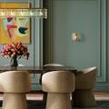 Duvernell Wall Sconce shown in a dining room with green walls and beige upholstered chairs