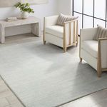 Modern living room setup with rug centered between two cream armchairs.