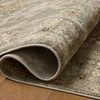 Close-up of rug folded over on hardwood floor highlighting backing and flexible polyester material