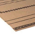 Close-up angled view highlighting textured woven faux jute fibers and detailed brown patterns on rug edge