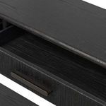 Close-up of tapering black wooden leg and underside of lower shelf