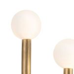Close-up showing top of white glass globe and brass sconce arm with brushed metal texture