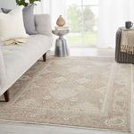 Rug placed in modern living space with gray sofa, knit pouf, and natural light from window