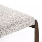 Side close-up of the fabric wrapping on the bench edge and the wooden leg's smooth finish