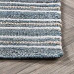 Oblique angle close-up showing detailed weave and natural fiber texture on Del Mar rug corner on wood floor