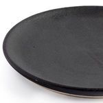 Side view close-up of matte black salad plate highlighting the subtle matte finish and rim curve