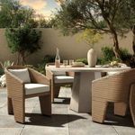 Three-quarter rear angle highlighting chair's curved wicker back and three-legged base