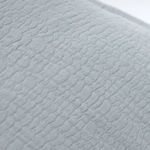 Macro close-up showing wavy pebbled texture of light gray cotton fabric on Waverly duvet