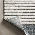 Hagen White Ocean Rug with curled corner revealing woven backing in ocean blue tones.
