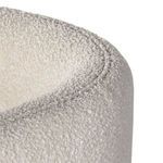 Close view of rounded top edge of Adriel chair backrest with looped boucle fabric texture