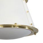 angled close-up focusing on bottom half of white shade and brass details on the fixture