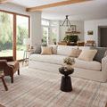 Interior living room scene with Ember Clay / Mist Rug placed under coffee table in front of beige sofa with natural wood b...