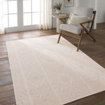 Rug in living room setting with beige cushioned chair, side table, and wood plank floor