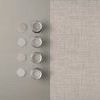 Rustic Weft Wallpaper next to coordinating paint sample pots on a gray surface