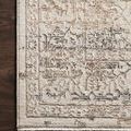 Close-up on rug corner showing intricate distressed pattern and soft fiber texture on dark wood floor