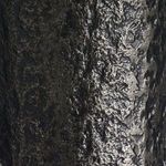 Detailed view of hand-forged black metal texture on lamp base